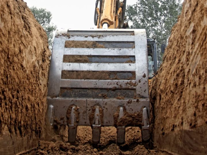Large backhoe digging a trench