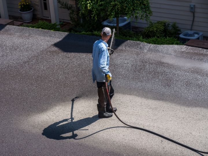 Labourer maintaining asphalt driveway