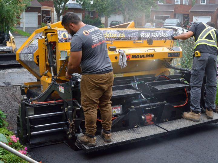 Machines re-paving a residential driveway