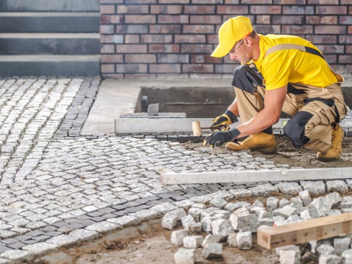 Labourer installing interlock brick walkway