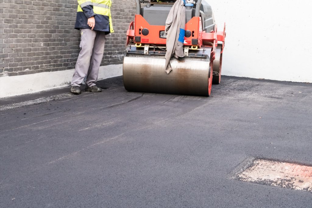 Asphalt driveway newly paved. an asphalt roller