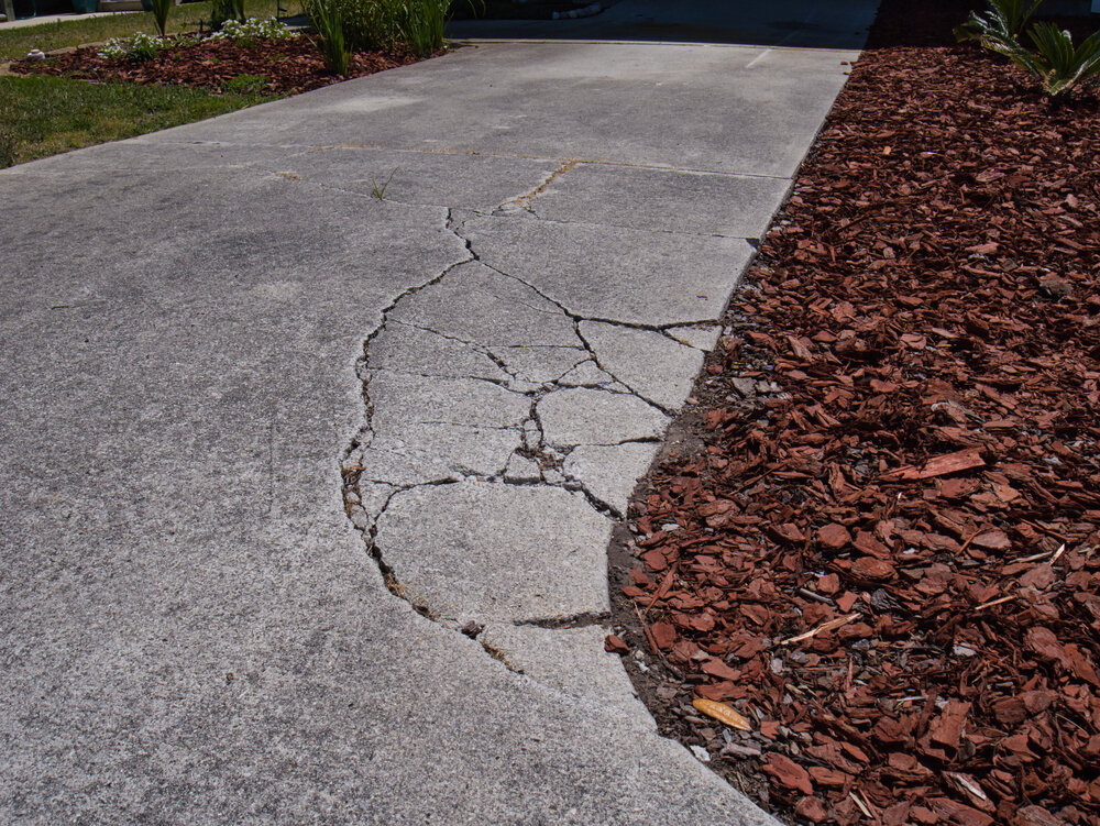 Driveway Repair and Maintenance. Cracked and sunken asphalt driveway.
