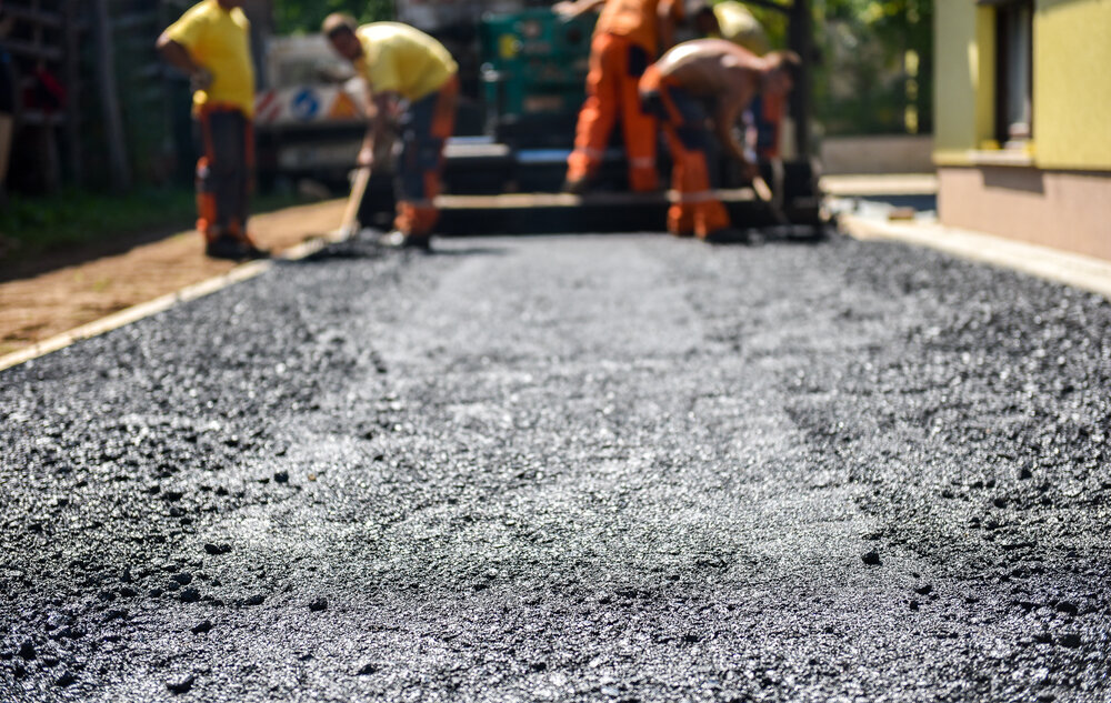 Team of workers laying a new New Driveway Asphalt Paving.