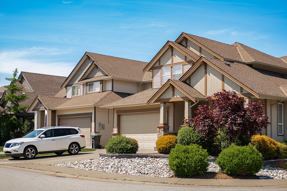 Big custom houses with nicely landscaped front yard and Residential Asphalt Paving driveway to garage in the suburbs