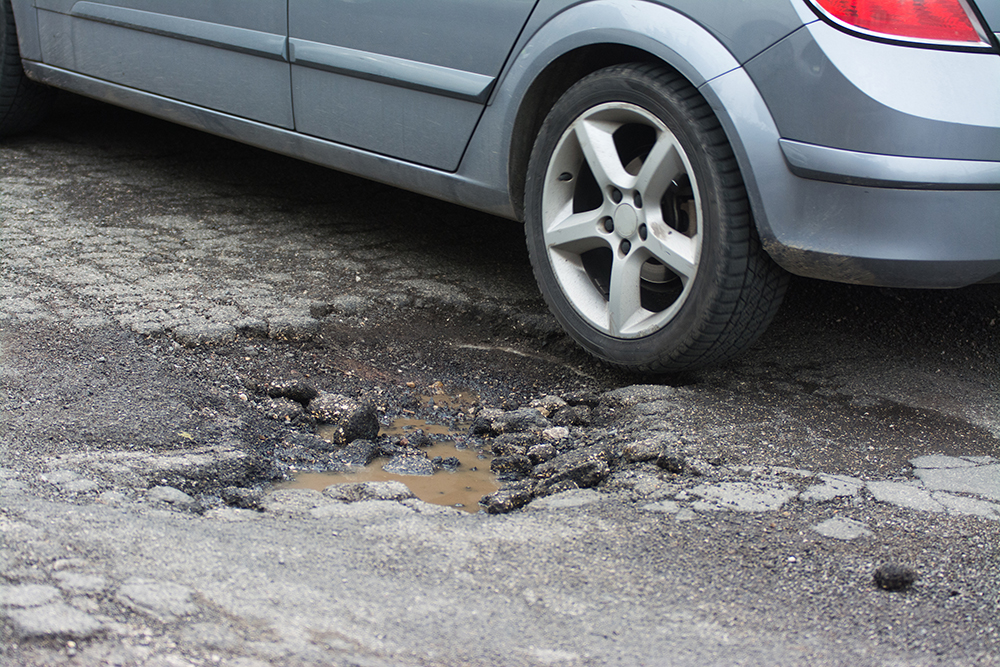 Big pothole caused by freezing and rain and why Regular Asphalt Maintenance is needed