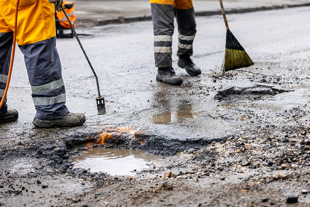 pothole repair asphalt maintenance service workers working on the road
