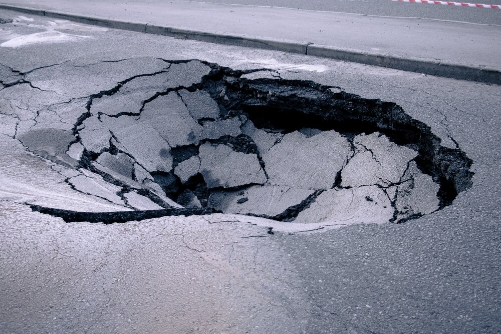 Asphalt Maintenance, A Large Pothole In The Asphalt driveway.