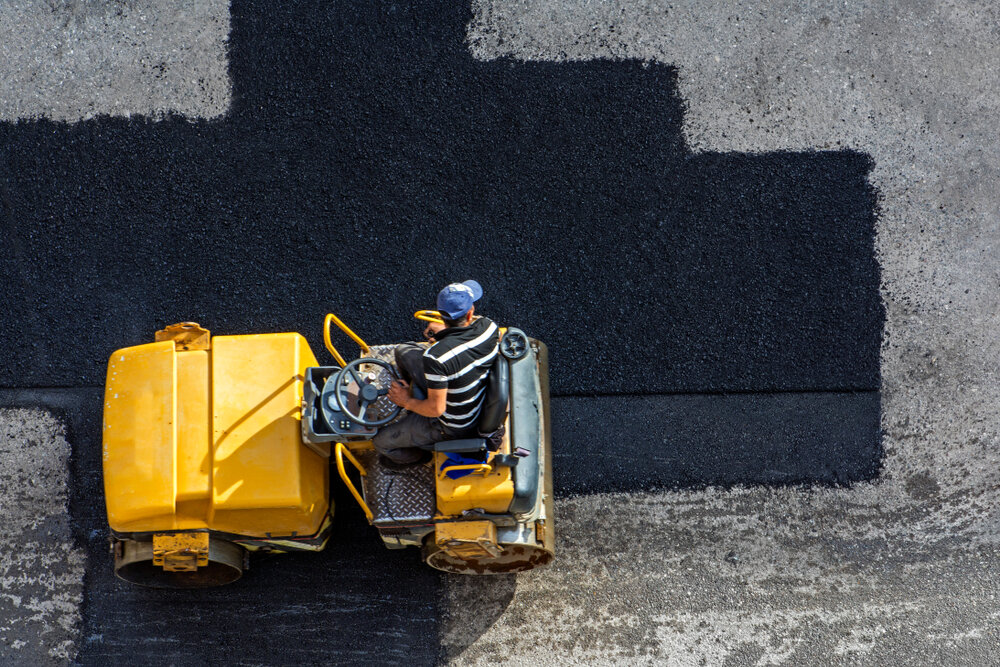 Commercial Paving Maintenance. Aerial View Of Asphalting Construction Works With Commercial Repair Equipment.